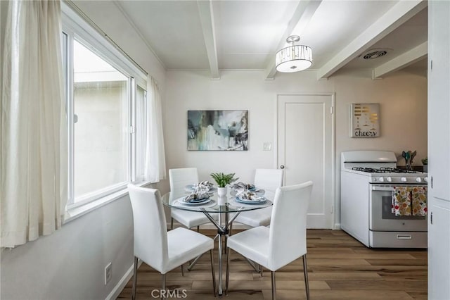 dining area with visible vents, wood finished floors, and beam ceiling