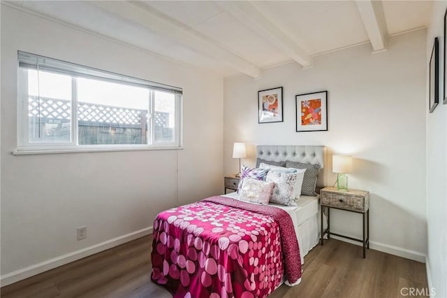 bedroom with baseboards, wood finished floors, and beam ceiling
