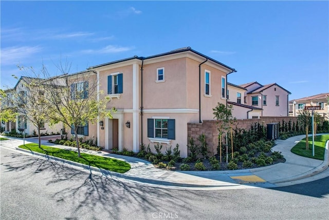 view of front of house with fence and stucco siding