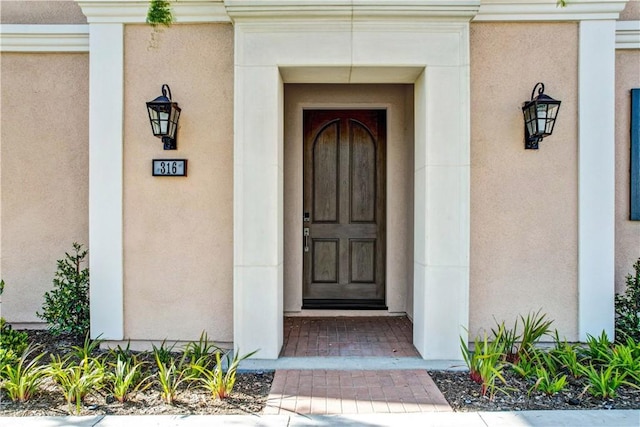 doorway to property featuring stucco siding