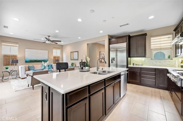 kitchen with visible vents, an island with sink, appliances with stainless steel finishes, light countertops, and a sink