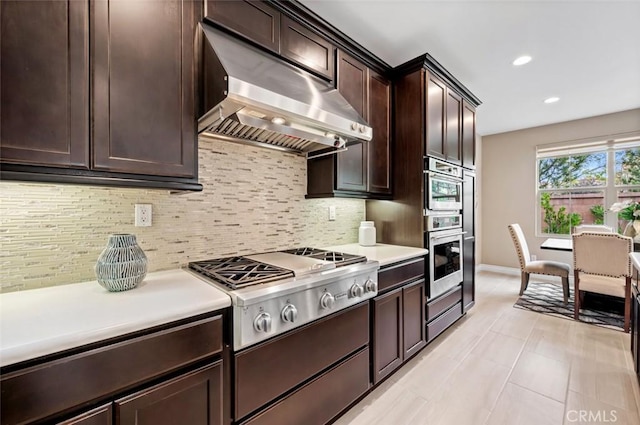 kitchen with stainless steel gas cooktop, exhaust hood, light countertops, dark brown cabinets, and backsplash