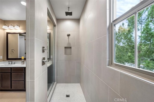 bathroom featuring a tile shower and vanity