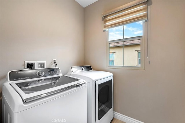 laundry area featuring laundry area, washing machine and dryer, and baseboards