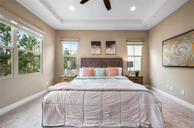 carpeted bedroom featuring a tray ceiling, baseboards, and recessed lighting