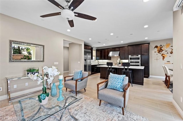 living room featuring recessed lighting, ceiling fan, and baseboards