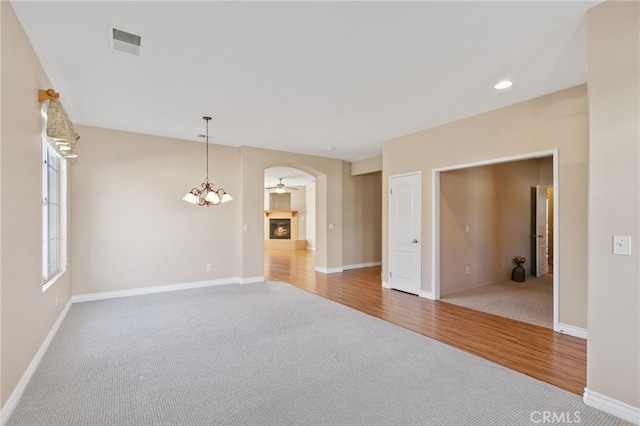 carpeted spare room featuring a chandelier