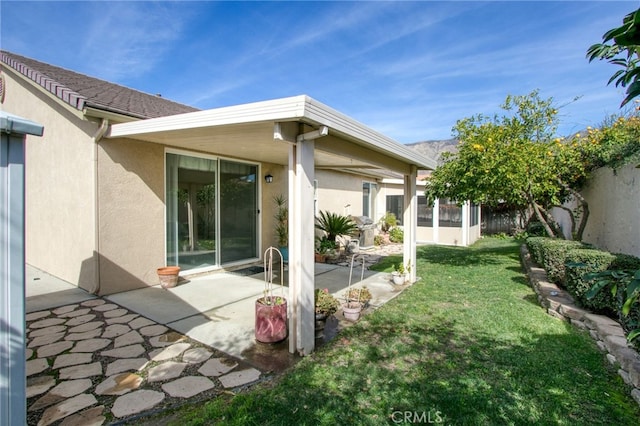 back of property featuring a patio and a yard