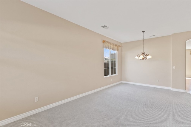 unfurnished room featuring carpet flooring and a chandelier