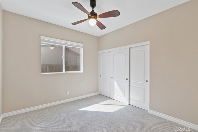 unfurnished bedroom with a closet, light colored carpet, and ceiling fan