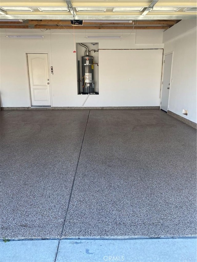 garage with strapped water heater and a garage door opener