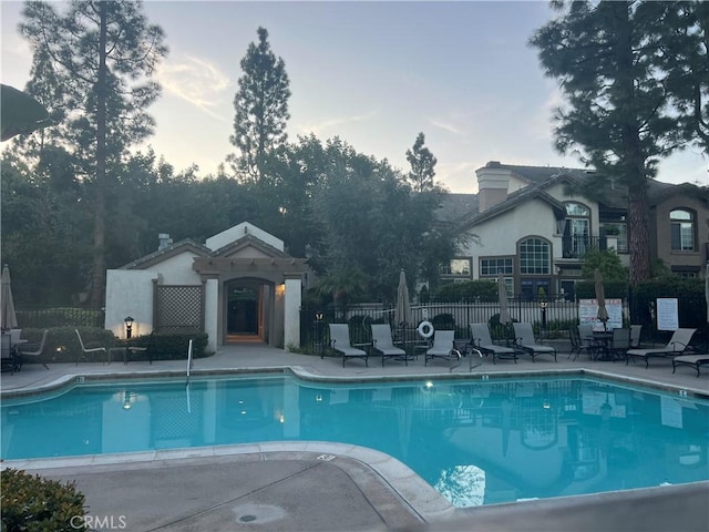 community pool featuring fence and a patio