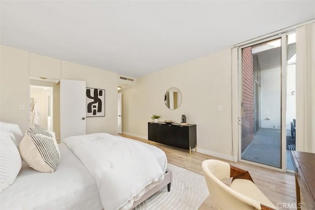 bedroom with access to exterior and light wood-type flooring