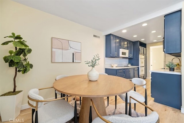 dining area featuring sink and light hardwood / wood-style floors