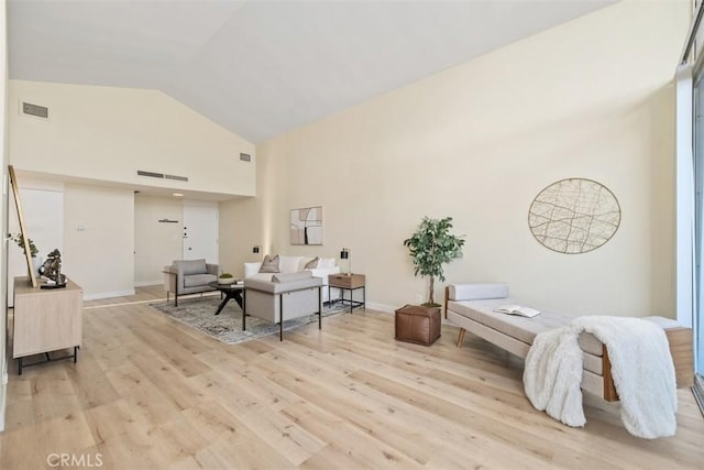 living room with high vaulted ceiling and light hardwood / wood-style floors