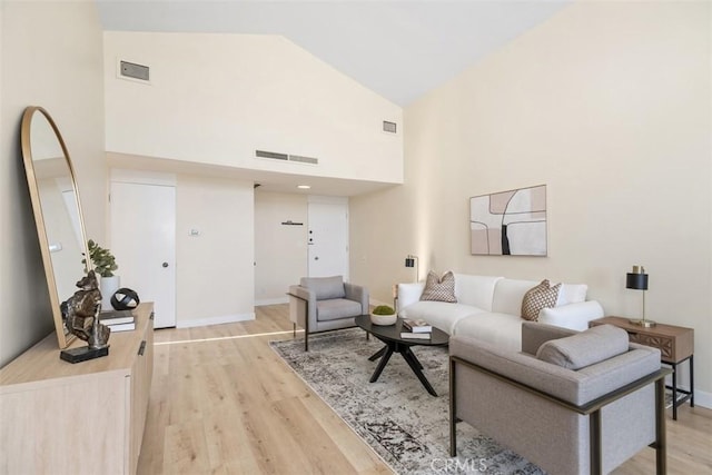 living room with high vaulted ceiling and light hardwood / wood-style floors