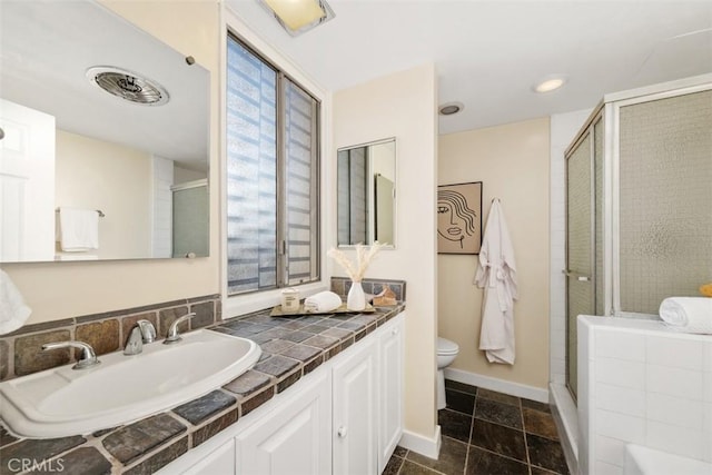 bathroom featuring vanity, an enclosed shower, and toilet