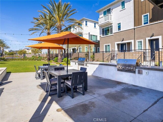 view of patio / terrace with grilling area, exterior kitchen, fence, and outdoor dining area
