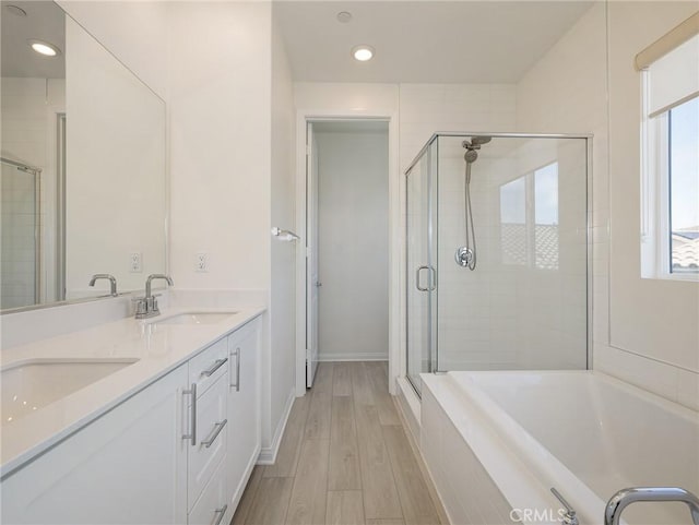 full bathroom featuring a sink, baseboards, a shower stall, and wood finished floors