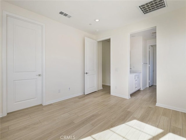 unfurnished bedroom featuring baseboards, visible vents, and light wood finished floors