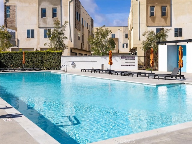 pool with a patio and fence