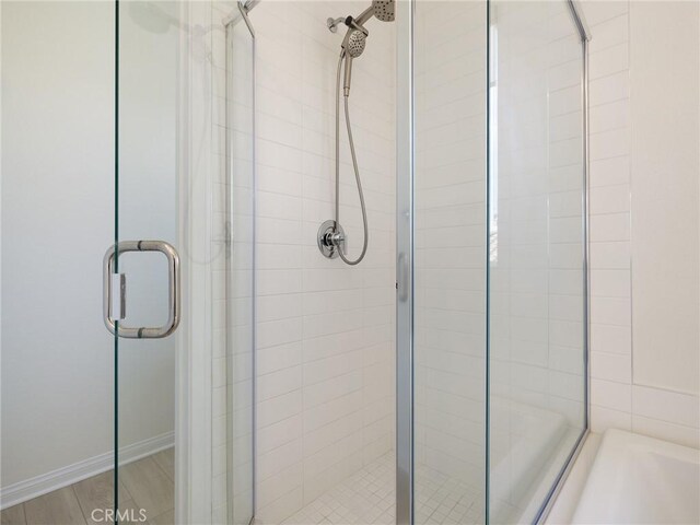 full bath featuring a bath and a stall shower