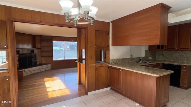 kitchen featuring an inviting chandelier, sink, dishwasher, decorative light fixtures, and kitchen peninsula