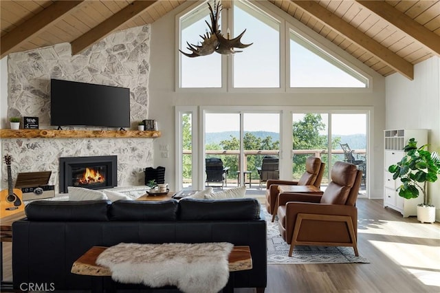 living room with wood-type flooring, a fireplace, beam ceiling, and wooden ceiling