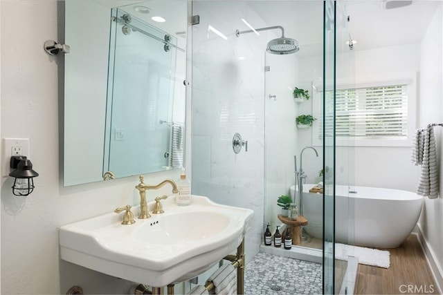 bathroom featuring independent shower and bath, hardwood / wood-style flooring, and sink