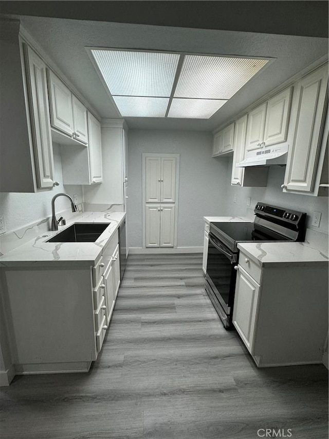 kitchen featuring sink, stainless steel range with electric stovetop, white cabinetry, and light hardwood / wood-style flooring