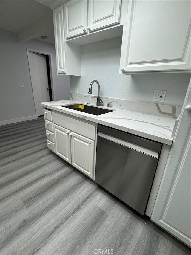 kitchen featuring stainless steel dishwasher, sink, white cabinetry, and light wood-type flooring