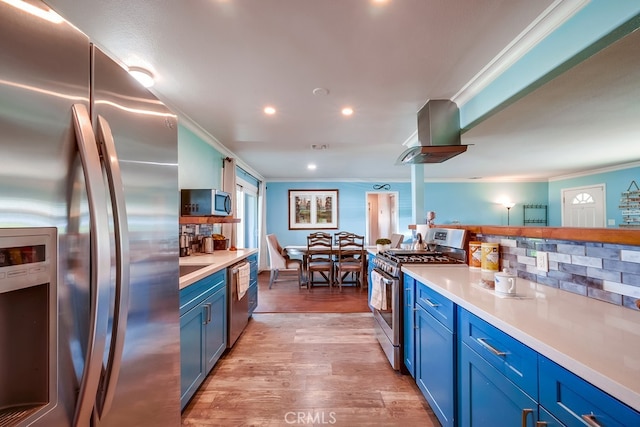 kitchen with blue cabinets, island exhaust hood, stainless steel appliances, and light countertops