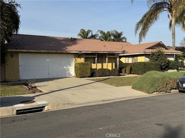 single story home with an attached garage, driveway, and stucco siding