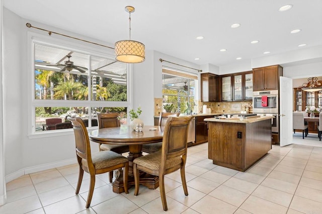 tiled dining space featuring ceiling fan