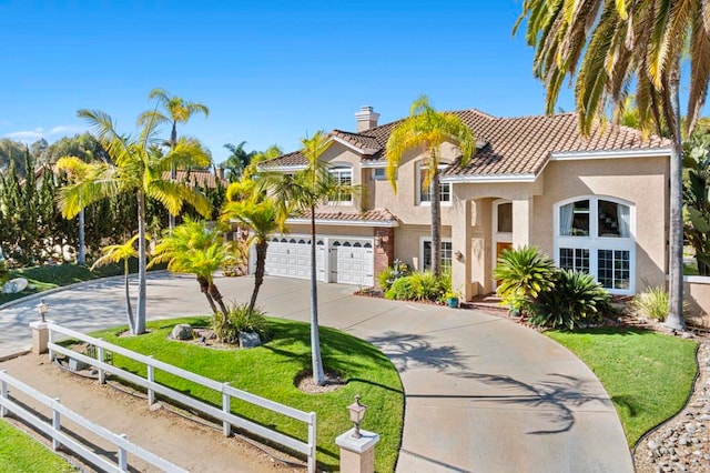 mediterranean / spanish house featuring a garage and a front yard