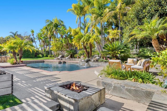 view of pool featuring a fire pit, a patio, and pool water feature