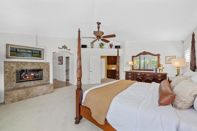 carpeted bedroom with lofted ceiling, a fireplace, and ceiling fan