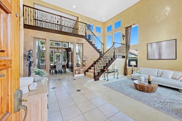 entryway with a towering ceiling and light tile patterned flooring