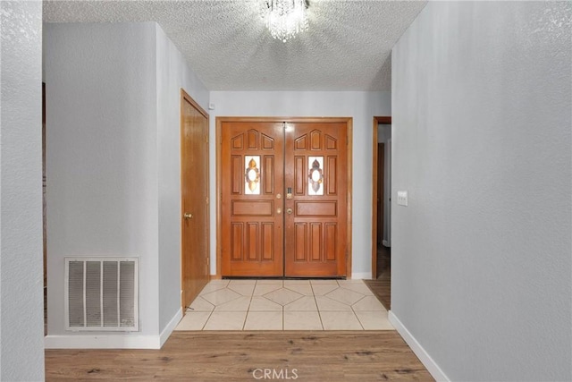 tiled foyer featuring a textured ceiling