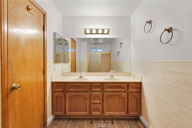 bathroom featuring hardwood / wood-style flooring, tile walls, and vanity