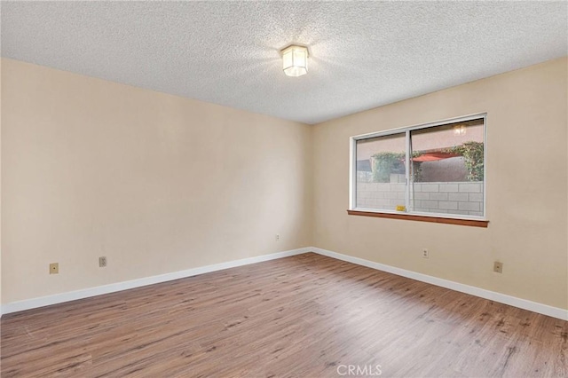 unfurnished room featuring wood-type flooring and a textured ceiling