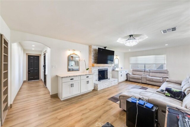 5058 Rose Ave, Riverside, CA 92505 - living room featuring a fireplace, light wood-type flooring, visible vents, arched walkways, and recessed lighting