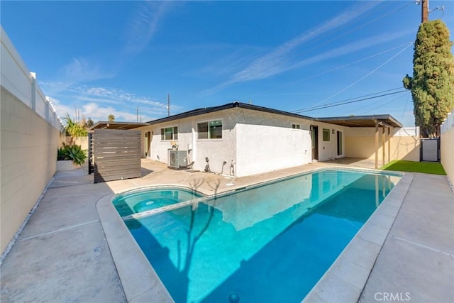 5058 Rose Ave, Riverside, CA 92505 - back of house featuring a pool with connected hot tub, a patio area, stucco siding, and fence