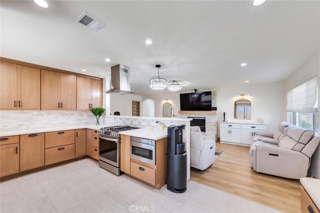 5058 Rose Ave, Riverside, CA 92505 - kitchen with gas stove, wall chimney range hood, a peninsula, and open floor plan