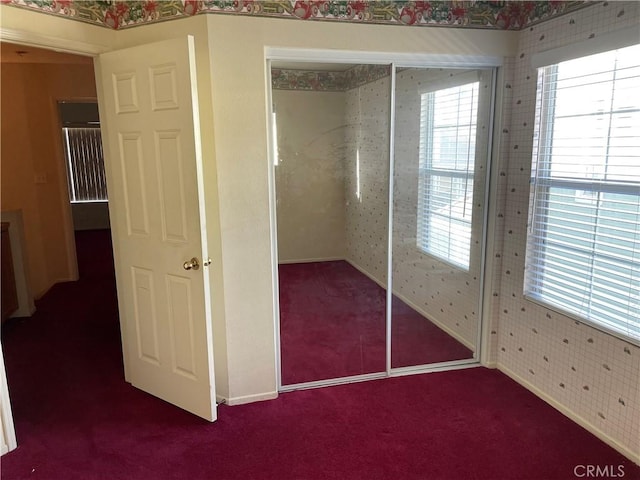 unfurnished bedroom featuring a closet and dark colored carpet