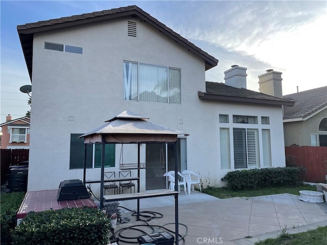 rear view of house with a gazebo and a patio area