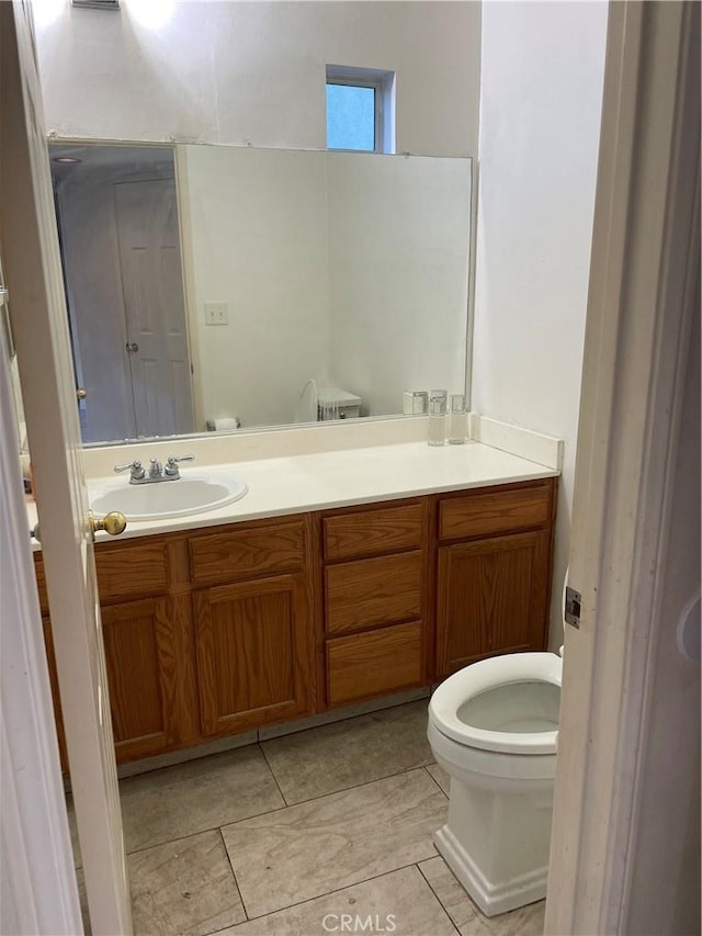 bathroom with vanity, toilet, and tile patterned flooring