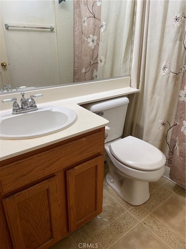 bathroom featuring vanity, tile patterned floors, and toilet