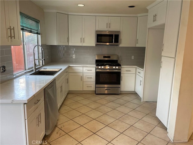 kitchen featuring white cabinetry, appliances with stainless steel finishes, sink, and backsplash