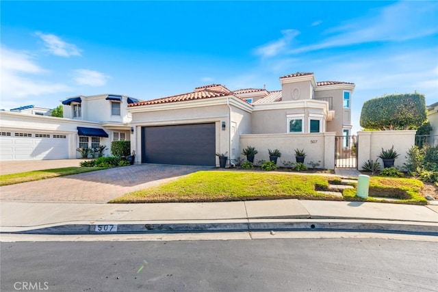 mediterranean / spanish house featuring decorative driveway, stucco siding, an attached garage, fence, and a tiled roof